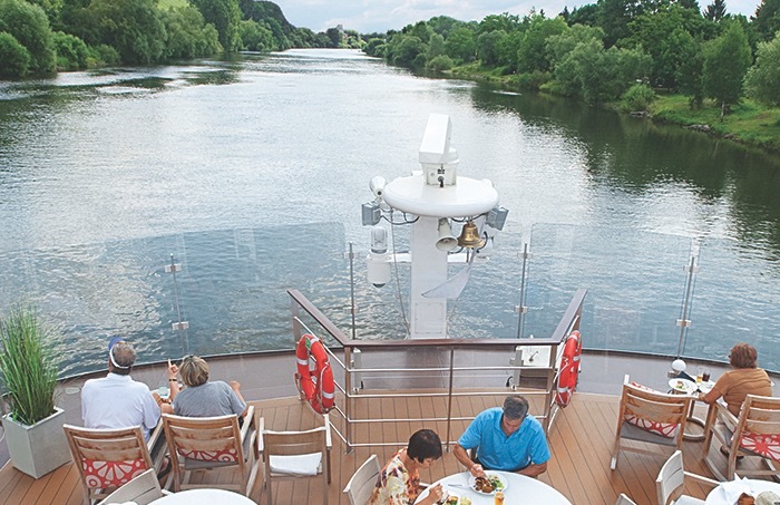 Diners enjoy a meal on deck a Viking longship during a European river cruise